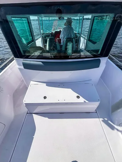  Yacht Photos Pics 2022 Axopar 28 CABIN boat interior with seating, navigating on water.