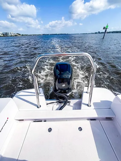  Yacht Photos Pics 2022 Axopar 28 CABIN boat cruising on open water under a clear blue sky.