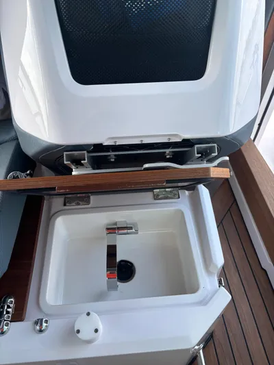  Yacht Photos Pics 2022 Axopar 28 CABIN boat sink with wooden cover and modern faucet.