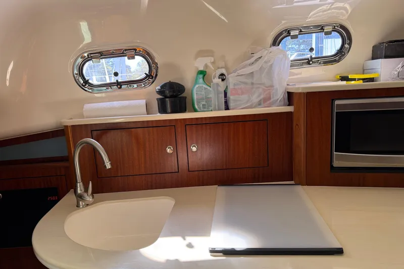 Yacht Photos Pics Kitchen area of 2015 Pursuit OS 385 Offshore boat with sink and microwave.