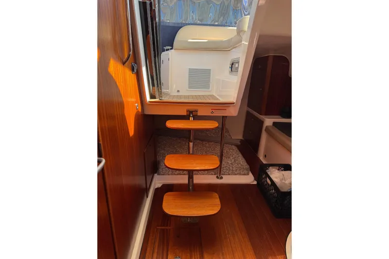  Yacht Photos Pics Interior view of 2015 Pursuit OS 385 Offshore boat with wooden steps and cozy cabin.