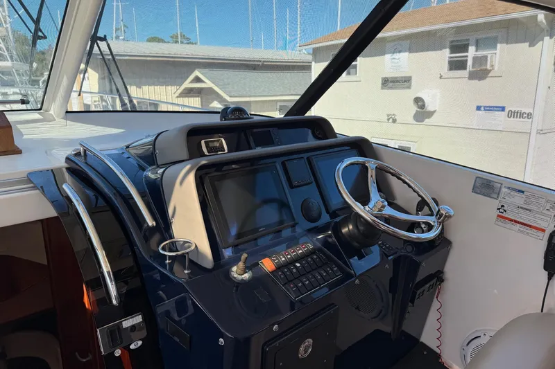  Yacht Photos Pics Helm of 2015 Pursuit OS 385 Offshore boat with steering wheel and navigation controls.
