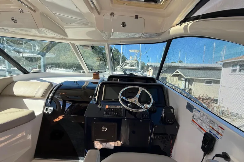  Yacht Photos Pics 2015 Pursuit OS 385 Offshore boat interior with steering wheel and navigation controls.