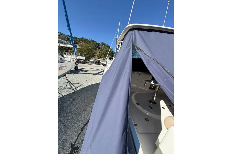  Yacht Photos Pics 2015 Pursuit OS 385 Offshore boat with blue cover, docked outdoors.