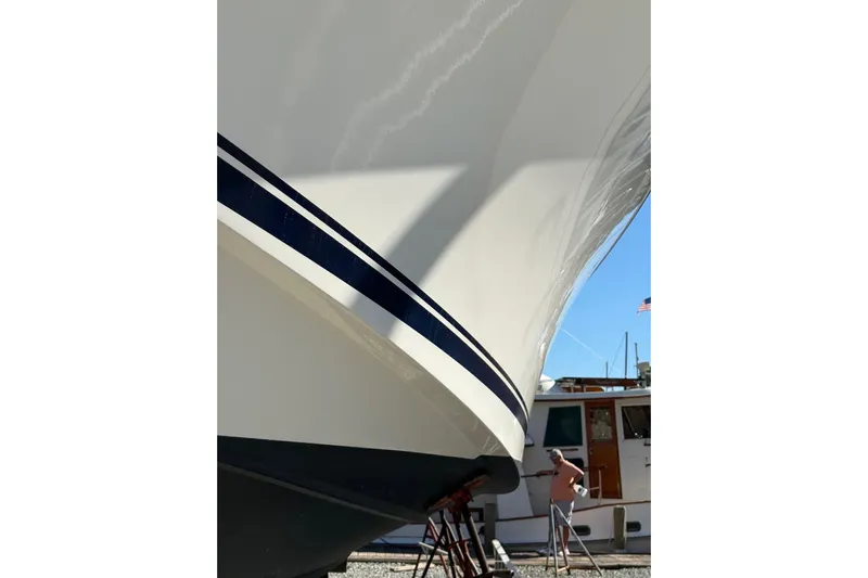  Yacht Photos Pics 2015 Pursuit OS 385 Offshore boat in dry dock, with a person nearby.