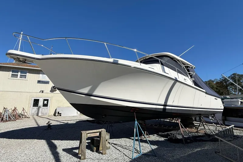  Yacht Photos Pics 2015 Pursuit OS 385 Offshore boat on dry dock under clear blue sky.
