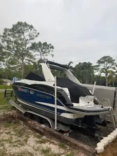  Yacht Photos Pics 2019 Monterey 295 Sport Yacht on trailer, parked outdoors with trees in background.