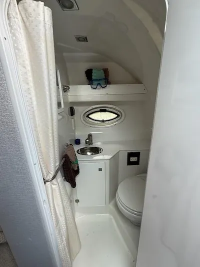  Yacht Photos Pics Compact bathroom in a 2019 Monterey 295 Sport Yacht with shower, sink, and toilet.
