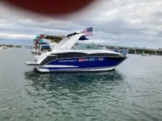  Yacht Photos Pics 2019 Monterey 295 Sport Yacht on water, American flag, cloudy sky.