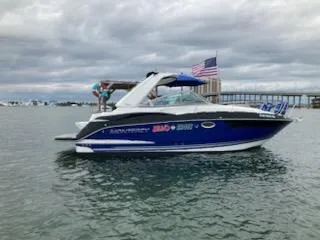  Yacht Photos Pics 2019 Monterey 295 Sport Yacht on water, American flag, cloudy sky.