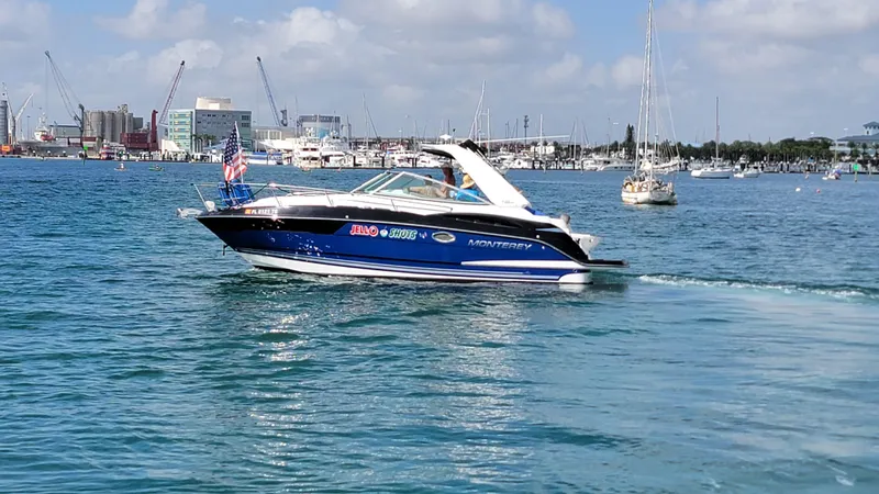  Yacht Photos Pics 2019 Monterey 295 Sport Yacht cruising in a busy harbor with cityscape background.