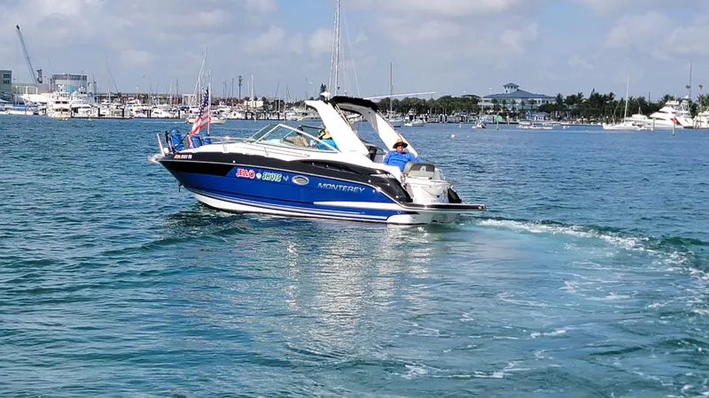  Yacht Photos Pics 2019 Monterey 295 Sport Yacht cruising in a marina under a partly cloudy sky.