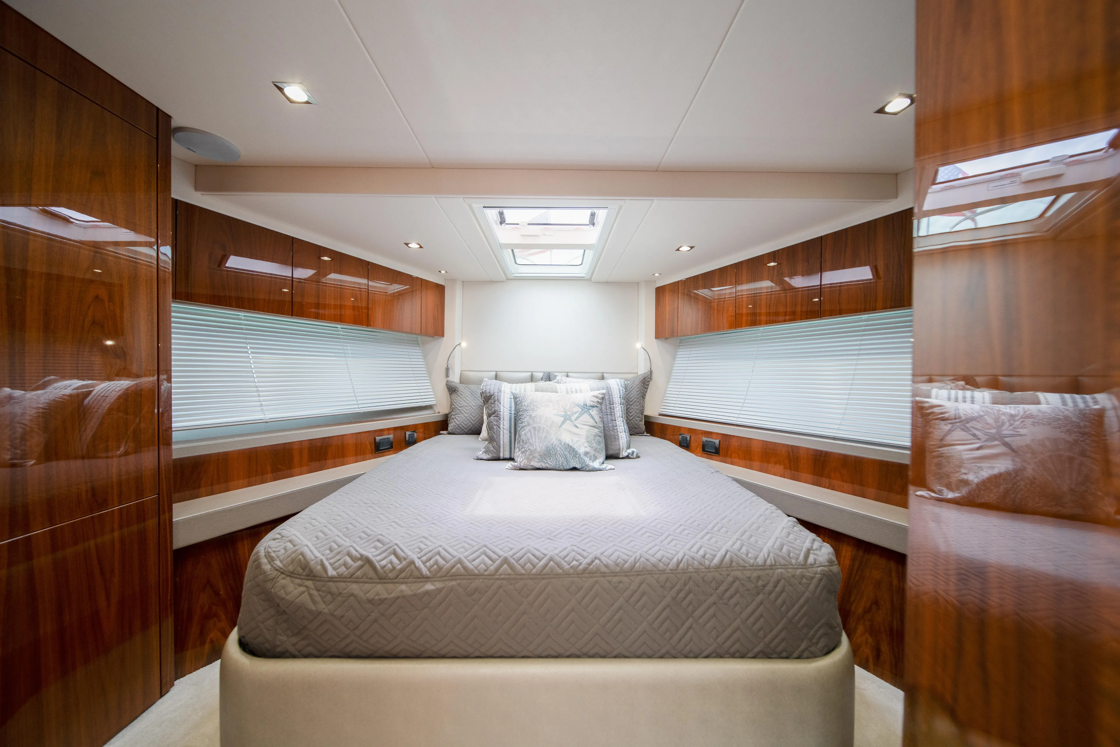 Why Knot Yacht Photos Pics Luxurious bedroom interior of 2020 Sunseeker 52 Manhattan yacht with elegant wood finishes.