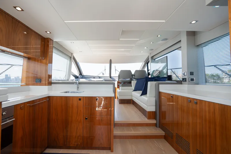 Why Knot Yacht Photos Pics Luxurious interior of 2020 Sunseeker 52 Manhattan yacht with modern kitchen and seating area.