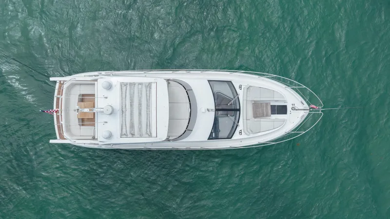 Why Knot Yacht Photos Pics Aerial view of 2020 Sunseeker 52 Manhattan yacht on turquoise water.