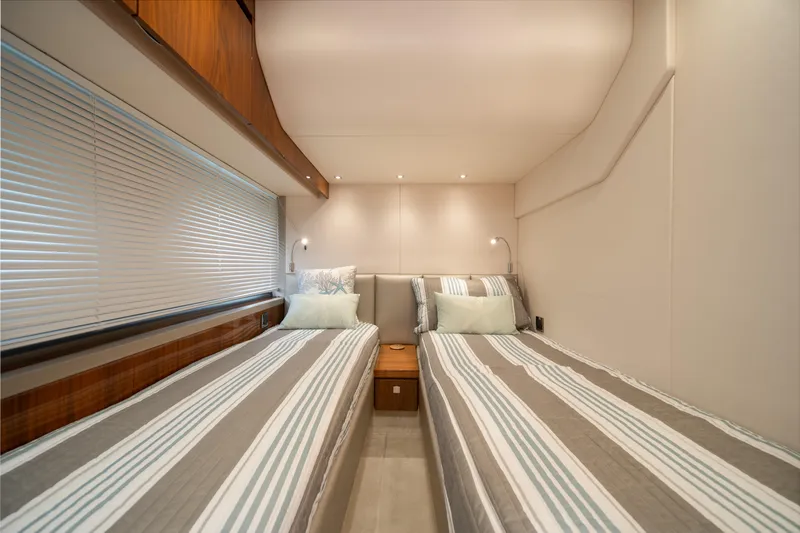 Why Knot Yacht Photos Pics Twin beds in a 2020 Sunseeker 52 Manhattan yacht cabin, featuring modern decor.