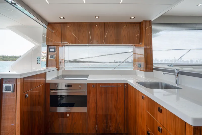 Why Knot Yacht Photos Pics Luxurious kitchen interior of 2020 Sunseeker 52 Manhattan yacht with modern wood cabinetry.