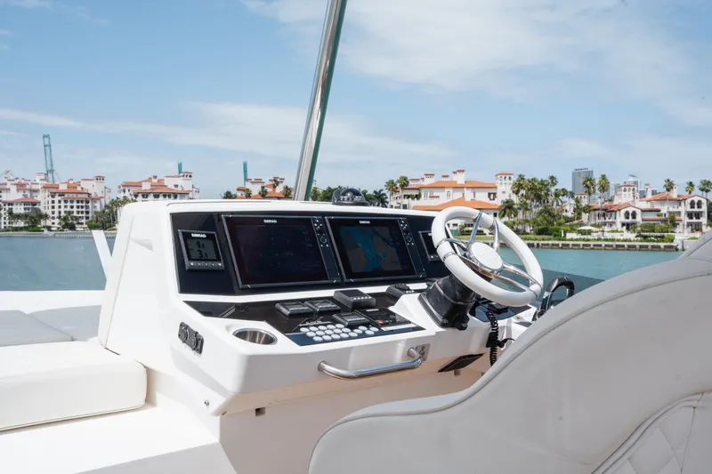 Why Knot Yacht Photos Pics Helm of 2020 Sunseeker 52 Manhattan yacht with modern controls and waterfront view.