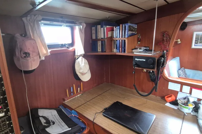  Yacht Photos Pics Cozy 1986 Hallberg-Rassy 49 yacht interior with navigation station and bookshelves.