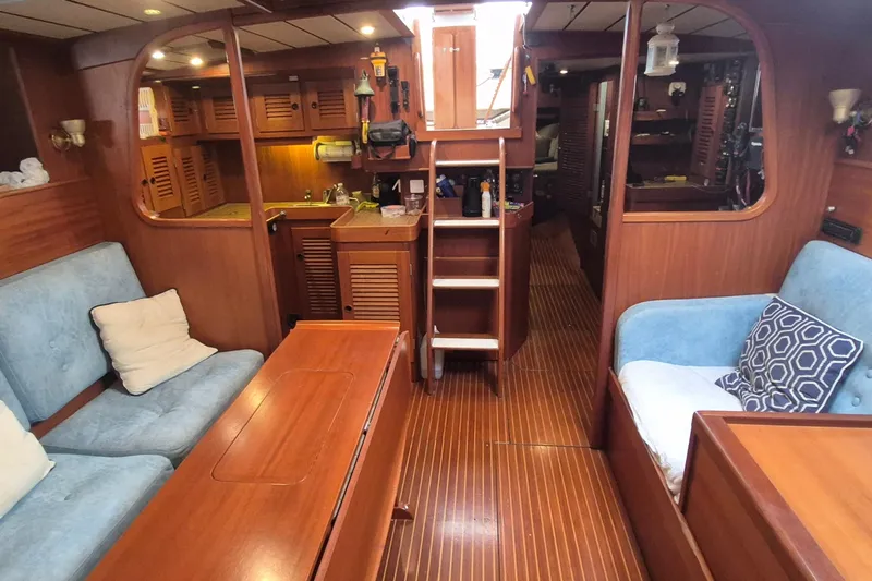  Yacht Photos Pics Interior of 1986 Hallberg-Rassy 49 yacht with wooden finish and blue seating.