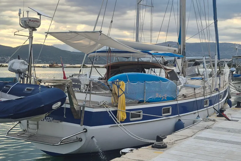  Yacht Photos Pics 1986 Hallberg-Rassy 49 sailboat docked at marina with scenic mountain backdrop.