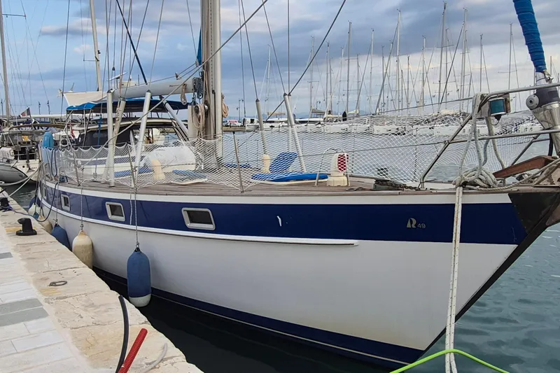  Yacht Photos Pics 1986 Hallberg-Rassy 49 sailboat docked at marina, featuring blue and white hull.