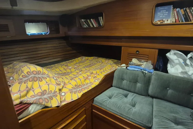  Yacht Photos Pics Cozy cabin interior of 1986 Hallberg-Rassy 49 sailboat with bed and bookshelves.