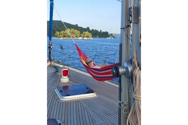  Yacht Photos Pics Person relaxing in a hammock on a 1986 Hallberg-Rassy 49 sailboat deck.