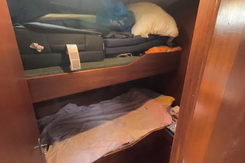  Yacht Photos Pics Cozy cabin bunk beds in 1986 Hallberg-Rassy 49 sailboat, with luggage and bedding.