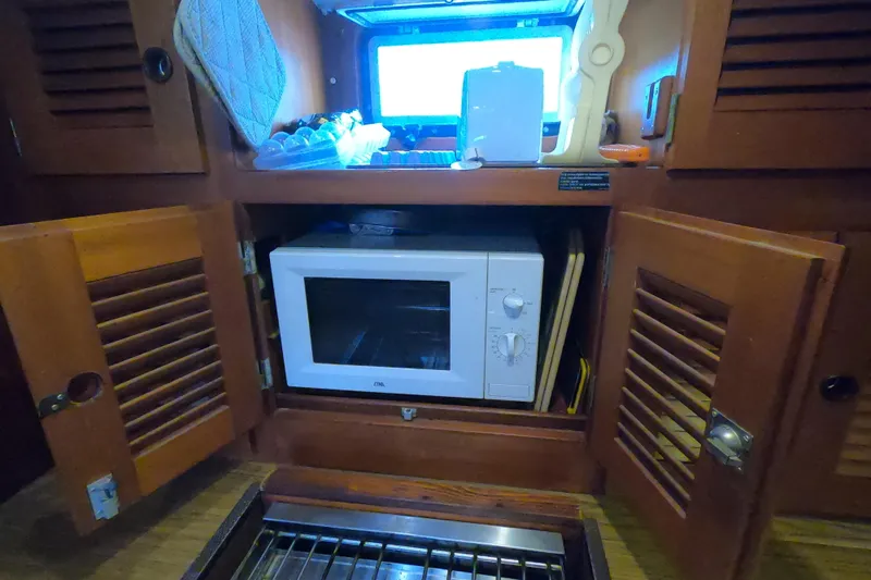  Yacht Photos Pics Microwave in wooden cabinet on 1986 Hallberg-Rassy 49 yacht kitchen.