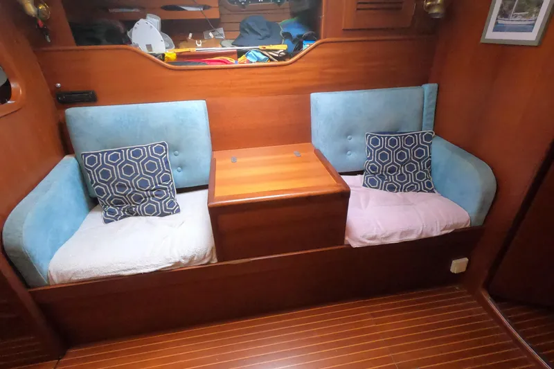  Yacht Photos Pics Interior of 1986 Hallberg-Rassy 49 yacht with blue seating and geometric cushions.