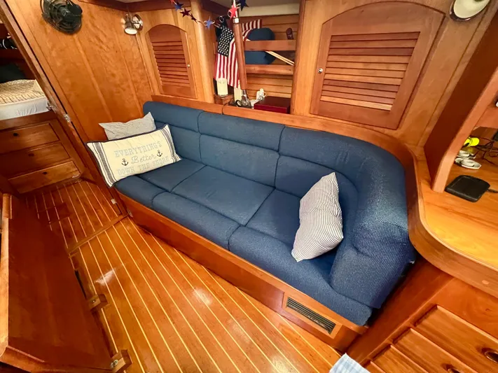 Vela Dare II Yacht Photos Pics Interior of 1999 Sabre 402 sailboat with blue cushioned seating and wooden cabinetry.