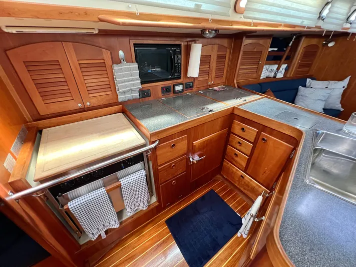 Vela Dare II Yacht Photos Pics 1999 Sabre 402 yacht kitchen with wooden cabinetry, stainless steel sink, and modern appliances.