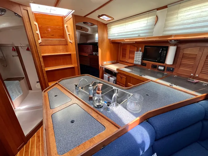 Vela Dare II Yacht Photos Pics 1999 Sabre 402 yacht interior with modern kitchen and wooden cabinetry.