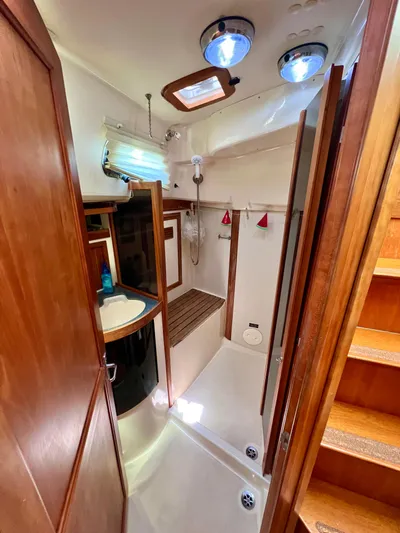 Vela Dare II Yacht Photos Pics 1999 Sabre 402 yacht bathroom with wooden cabinetry and modern fixtures.