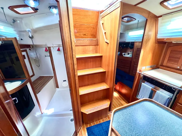 Vela Dare II Yacht Photos Pics Interior of a 1999 Sabre 402 sailboat with wooden stairs and cozy living space.