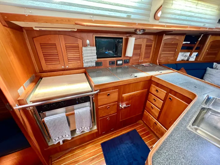 Vela Dare II Yacht Photos Pics 1999 Sabre 402 yacht kitchen with wooden cabinets and modern appliances.