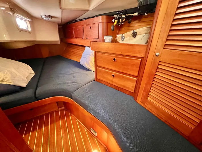 Vela Dare II Yacht Photos Pics 1999 Sabre 402 sailboat interior cabin with wooden cabinetry and blue cushions.