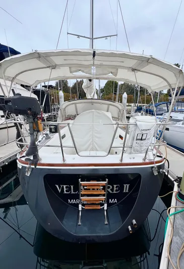 Vela Dare II Yacht Photos Pics 1999 Sabre 402 sailboat docked, rear view with canopy and ladder.