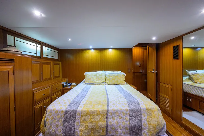 Change Of Latitude Yacht Photos Pics Luxurious bedroom interior of 2001 Ocean Alexander 602 yacht with wood paneling and cozy bedding.