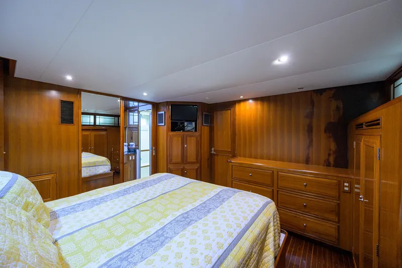Change Of Latitude Yacht Photos Pics Luxurious bedroom interior of 2001 Ocean Alexander 602 yacht with wood paneling and cozy bedding.
