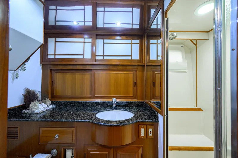Change Of Latitude Yacht Photos Pics Luxurious bathroom interior of 2001 Ocean Alexander 602 yacht with wooden cabinetry and granite countertop.