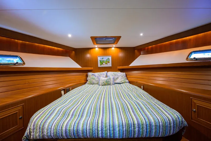 Change Of Latitude Yacht Photos Pics Luxurious cabin interior of 2001 Ocean Alexander 602 yacht with striped bedding.