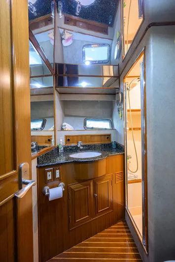 Change Of Latitude Yacht Photos Pics Luxurious bathroom in 2001 Ocean Alexander 602 yacht with wood accents and modern fixtures.
