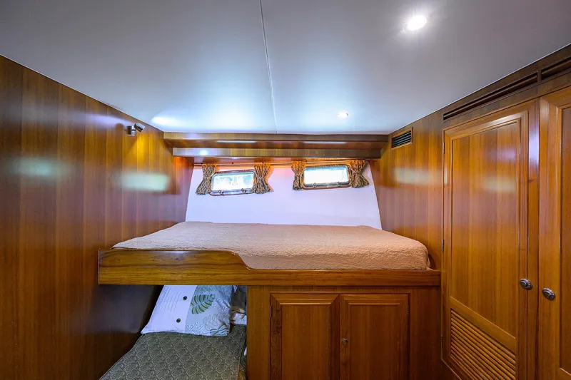 Change Of Latitude Yacht Photos Pics Luxurious wooden cabin interior of 2001 Ocean Alexander 602 yacht with cozy bedding.
