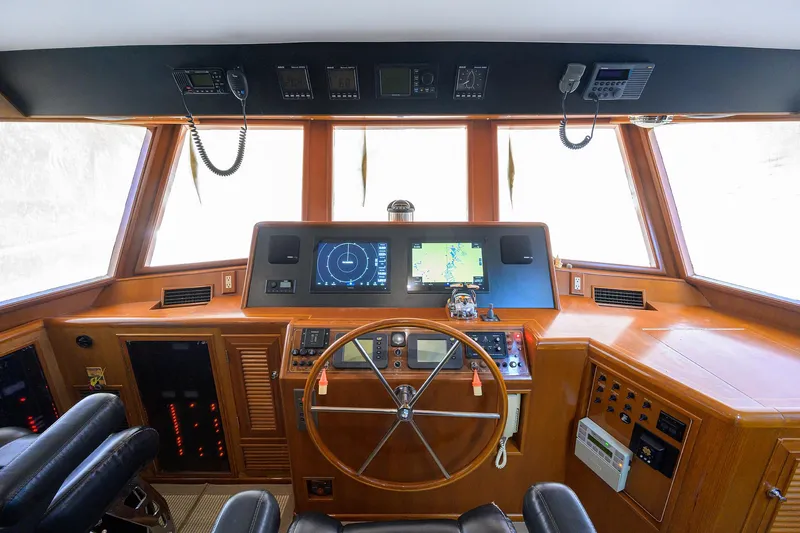 Change Of Latitude Yacht Photos Pics Cockpit of 2001 Ocean Alexander 602 yacht with navigation equipment and wooden steering wheel.