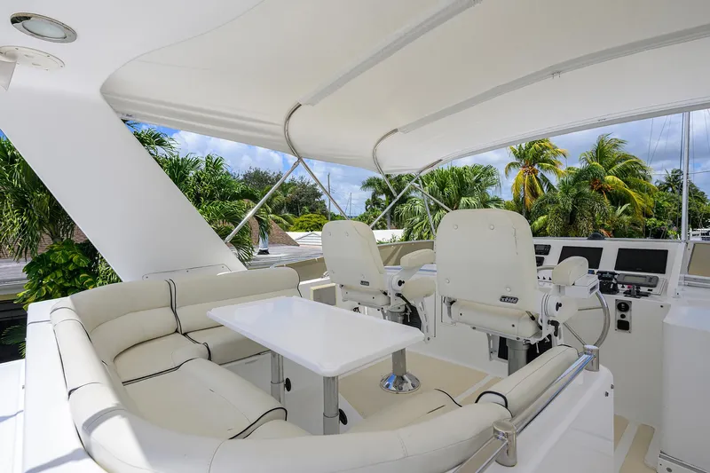 Change Of Latitude Yacht Photos Pics Luxurious 2001 Ocean Alexander 602 yacht interior with white seating and helm, surrounded by tropical scenery.