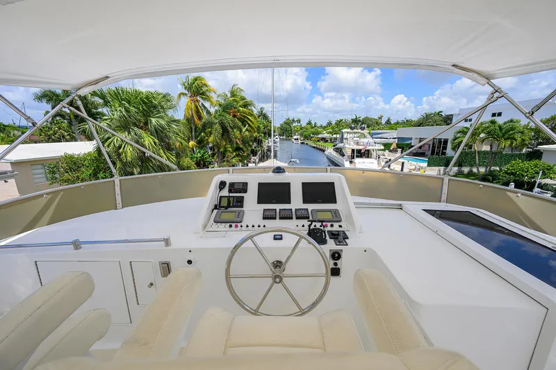 Change Of Latitude Yacht Photos Pics Flybridge view of 2001 Ocean Alexander 602 yacht, featuring helm station and tropical canal backdrop.