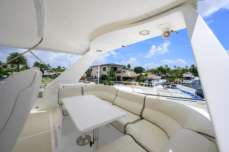 Change Of Latitude Yacht Photos Pics Luxurious 2001 Ocean Alexander 602 yacht deck with white seating and table, marina view.