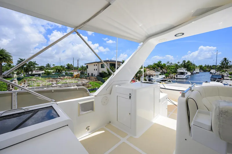 Change Of Latitude Yacht Photos Pics Luxurious Ocean Alexander 602 yacht deck, 2001 model, with marina view and clear blue sky.